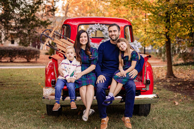 family on front of red truck