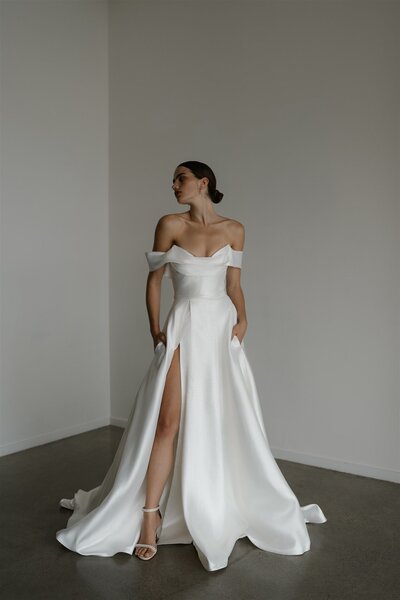 Bride in an off-the-shoulder gown with thigh-high slit.