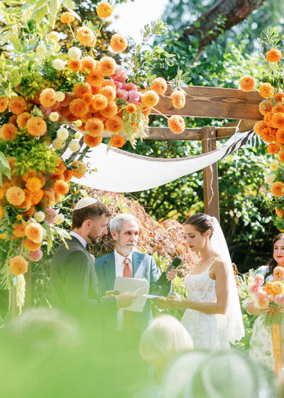bride and groom at jewish ceremony under chuppah