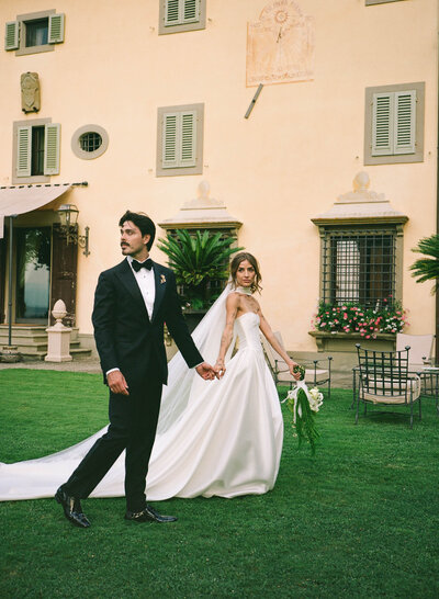 Elegant bride and groom in white vintage fiat car, Tuscany, Italy