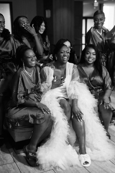Bride laughing with bridesmaids in matching robes
