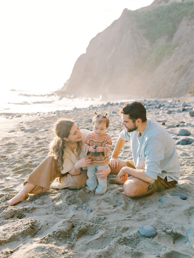 family sitting on the beach