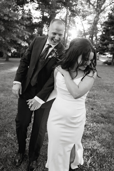 Bride and groom laugh together while holding hands during golden hour at rust manor house in leesburg, va