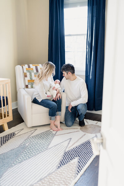 First time parents hold their precious new baby in the nursery.