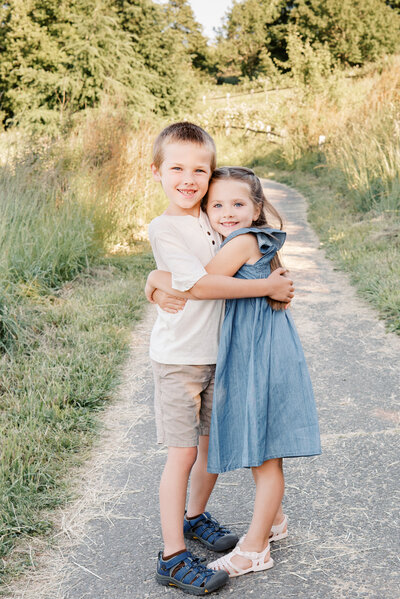 Brother and sister embracing on path