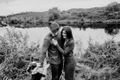 relaxed couples engagement photos with dog by lake