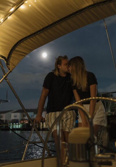Shelby Ann Photos, amelia island photographers, and her partner kissing on a boat