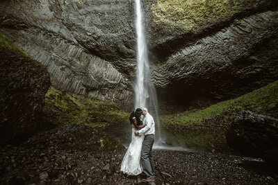Elope under a waterfall in the Oregon wilderness.