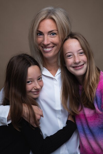 Moeder en dochters poseren samen tijdens een warme en spontane fotoshoot in de studio van Studio 2Shoot in Eijsden.