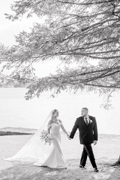 Bride and groom walking by the Skaneateles Lake