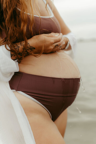 Pregnant mom at Wilmington beach wearing bathing suit