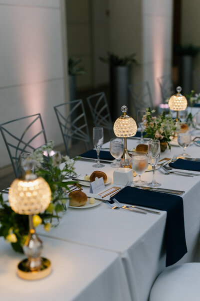 Long rectangle tablescape with lighted lamps and greenery