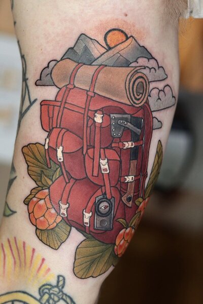 Neo traditional tatuering av en röd ryggsäck med berg och hjortron.