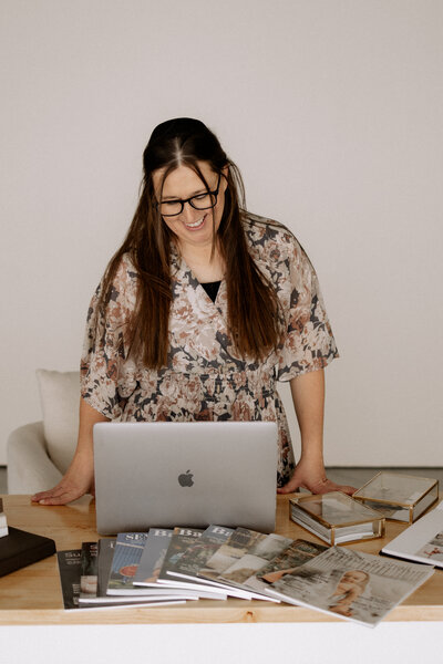 headshot of Mary Wiebe Photography looking at her computer.