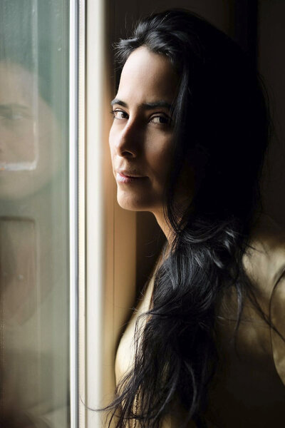 indoor portrait of Katherine Suarez facing window