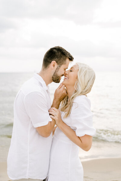 couple laughing and kissing on the beach
