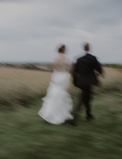 A blurred bride and groom running off into the sunset at their rochester, ny wedding. photo by dash and boheme photography