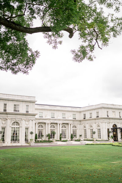 A wide view of Rosecliff Mansion’s stately white façade framed by lush greenery. This historic Newport, RI mansion offers breathtaking architecture and dreamy grounds for unforgettable wedding celebrations.