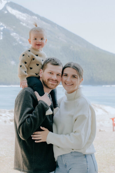 Family of 3 during a family photo session in Lake Minnewanka in Banff National Park