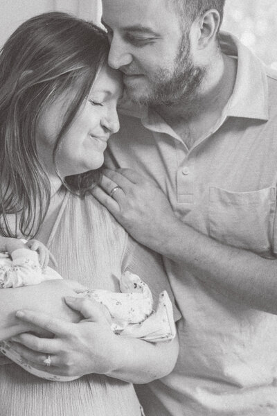 Couple cuddling their newborn during family portrait session