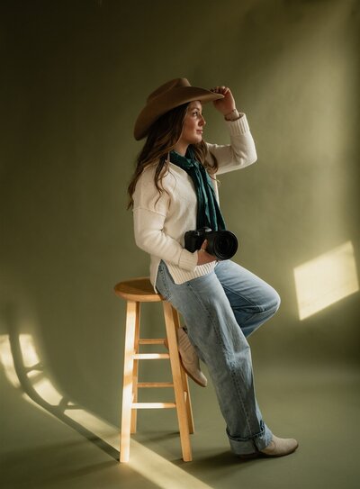 Studio portrait of a Wyoming-based wedding and lifestyle photographer, captured in a clean and professional setup with soft lighting and a relaxed pose.