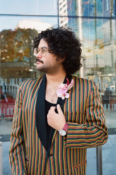 Groom poses for photos outside of City Hall in Portland, Oregon prior to his wedding.
