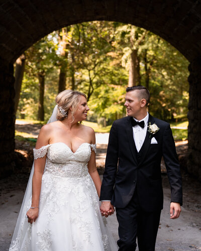 The bride and groom walking through Delaware Park before their wedding in Buffalo, NY.