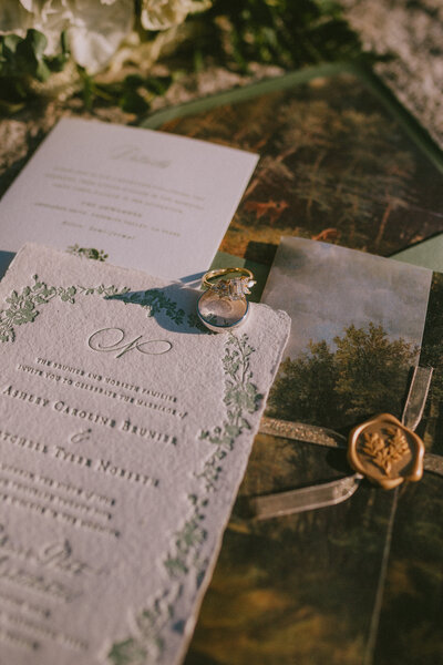 Wedding stationery suite with invitation, wax seal, and ring styled by Beyond the Event as part of stationery design services.
