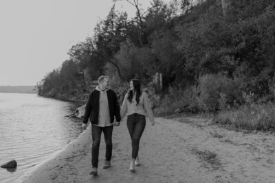couple walking near lake in wisconsin holding hands