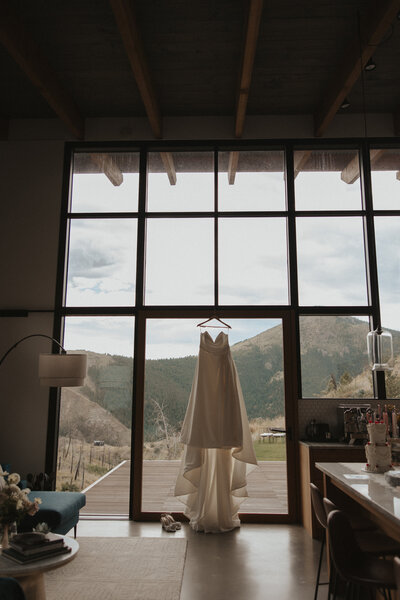 wedding photographer travels to boulder colorado for elopement. White wedding dress hanging with mountains in background