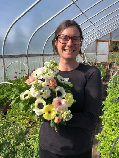 A woman holding spring flowers, representing a team member of Cassie Peters Legal, a business attorney in Eugene.