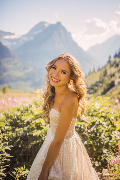 senior girl laughing in a glittery dress in glacier national park