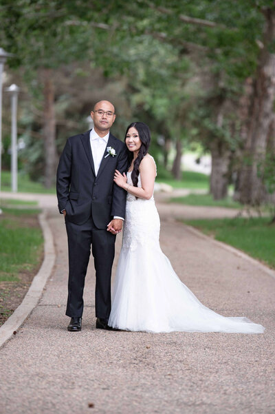 Bride and groom standing on a walking path in Saskatoon.