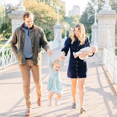 Family walks together on a bridge in Boston Public Gardens