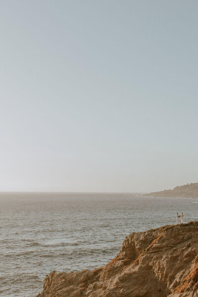 Big Sur CA Elopement. Couple in wedding attire standing on Big Sur Cliffside together