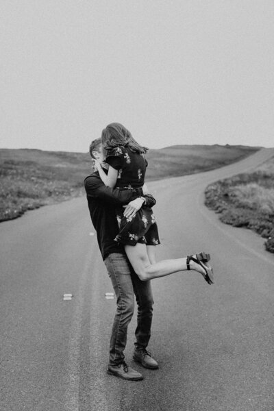 black and white image couple embracing in road