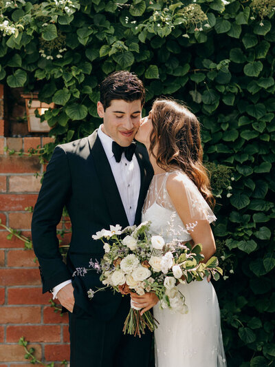 bride giving her groom a kiss.