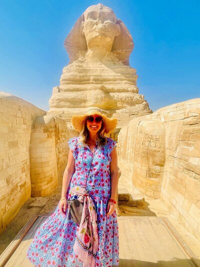 Spiritual coach Katie posing in a bright-colored dress.