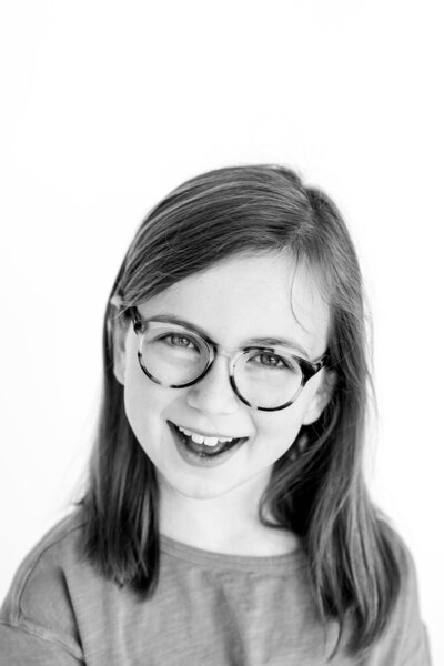 young girl with glasses smiling in personality portrait