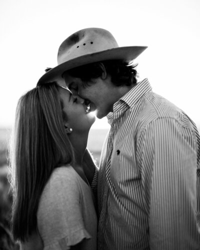 engaged couple walking through a field