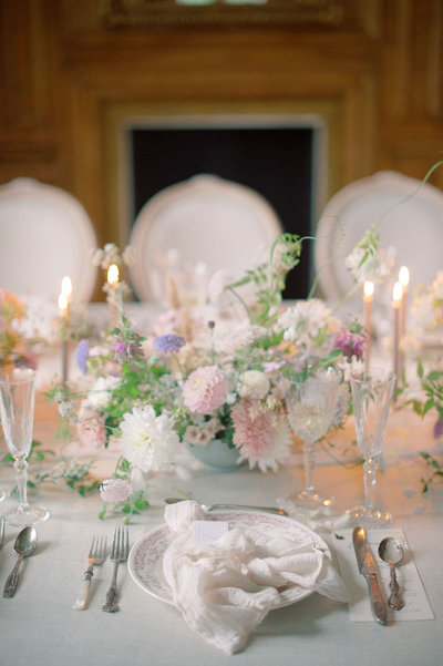 Romantic English manor house wedding place setting with cloth napkins and spring garden style centerpieces