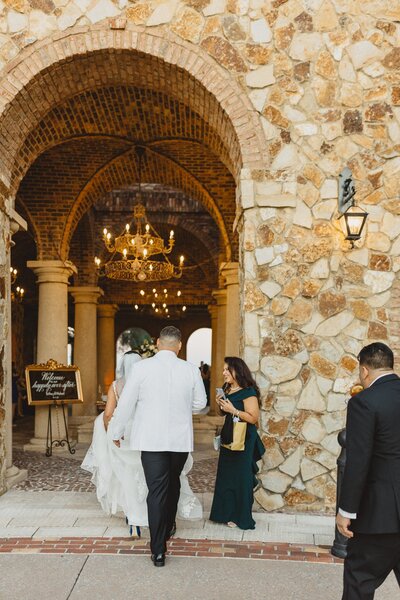 Stone archway entrance with bride and groom walking in