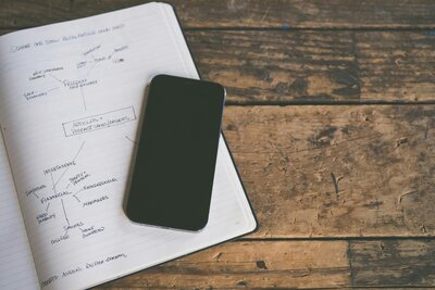 Notebook with a strategy diagram and a phone representing organizational planning.