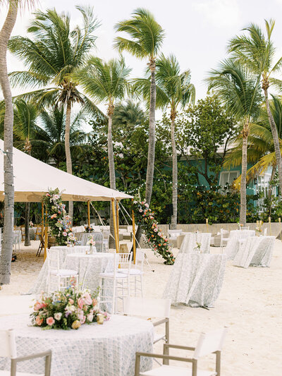 Epic tent entrance floral installation for tropical destination beach wedding in Exuma, Bahamas. Tropical florals in pink, orange, pale yellow, dusty blue, lavender, and mauve for private estate wedding. Destination floral design by Rosemary & Finch Floral Design.