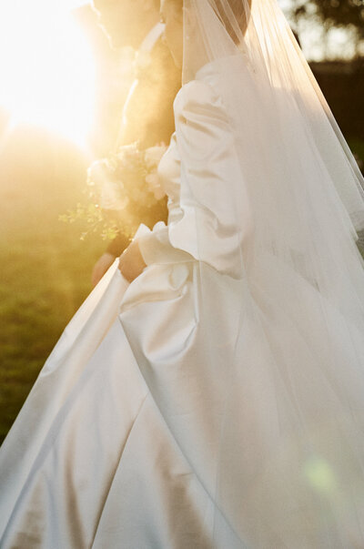 detail of brides dress and flowerswalking