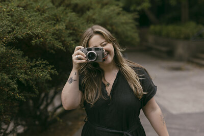woman holding camera up to her eye