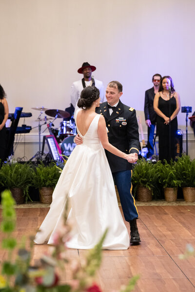 bride wearing white ball gown while dancing with groom wearing military uniform at Green Island Country Club in Columbus Georgia by Amanda Richardson Photography