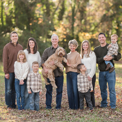 Family group photo with multiple generations and a pet dog