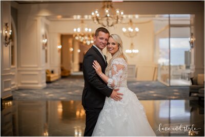 Tammy and Martin pose for a photo beneath chandeliers at the Ritz Carlton, Downtown Sarasota, FL.