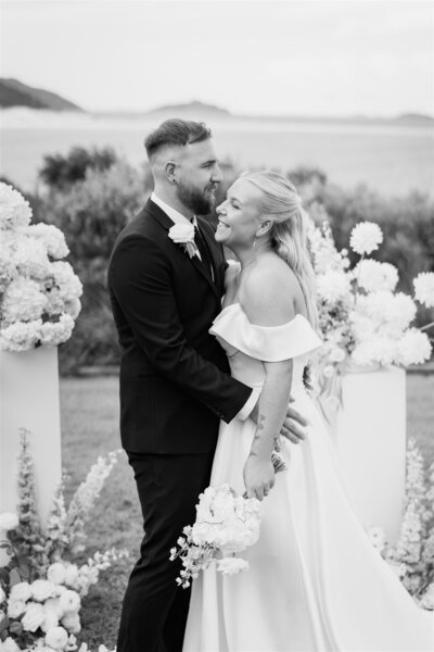 The groom's affectionate kiss brings a radiant smile to the bride, making her truly shine.